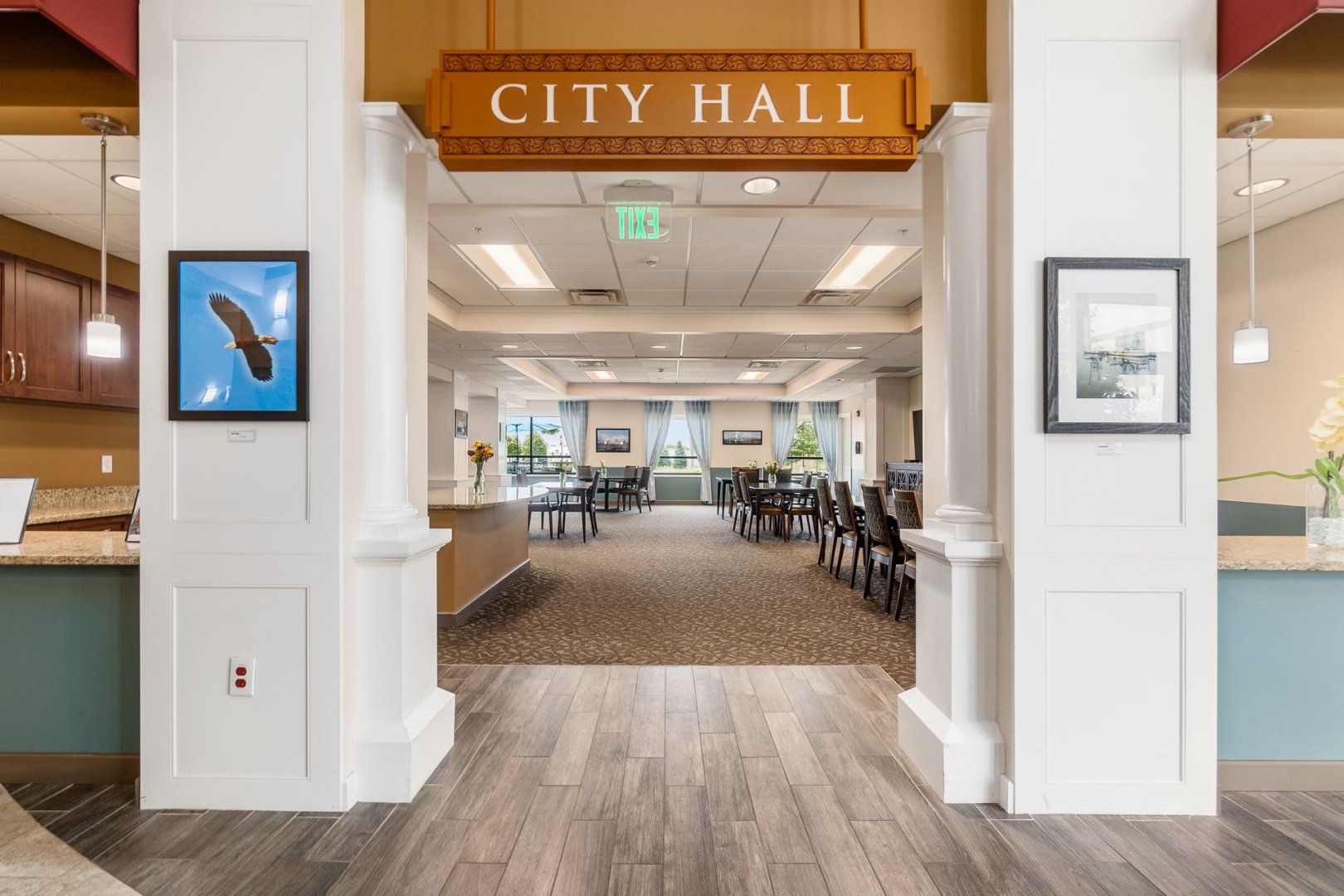 Entrance to dining area with City Hall sign inside senior living community.