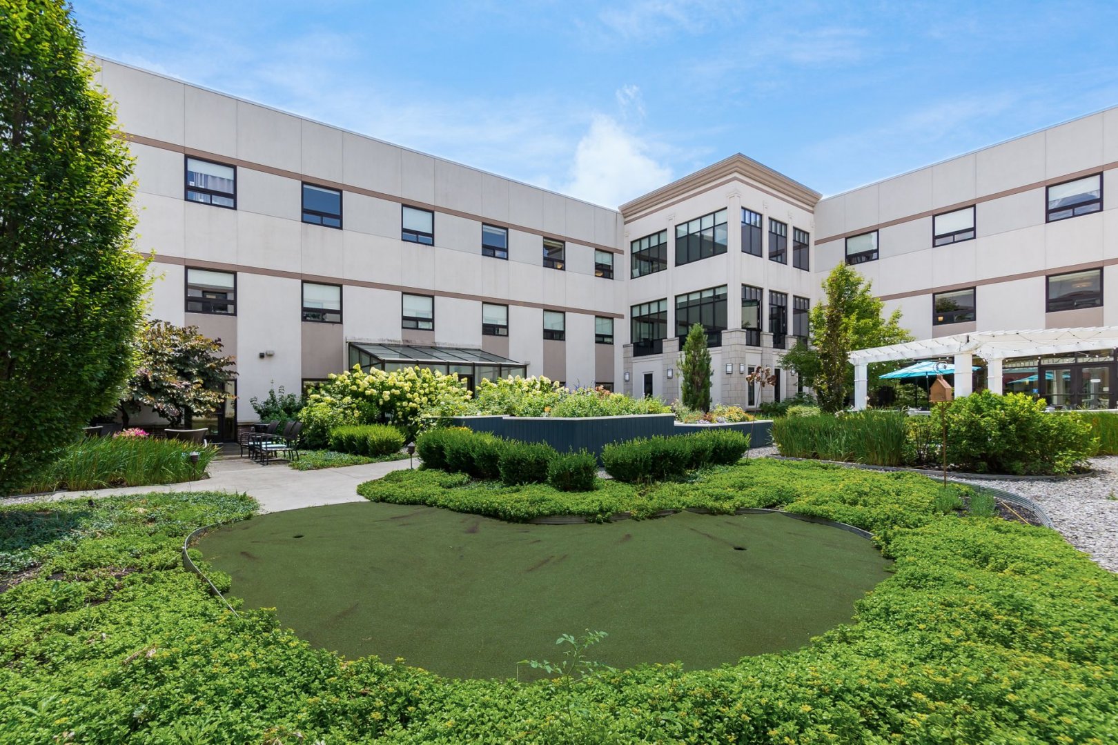 Exterior view of a senior living community with well-maintained garden and greenery.