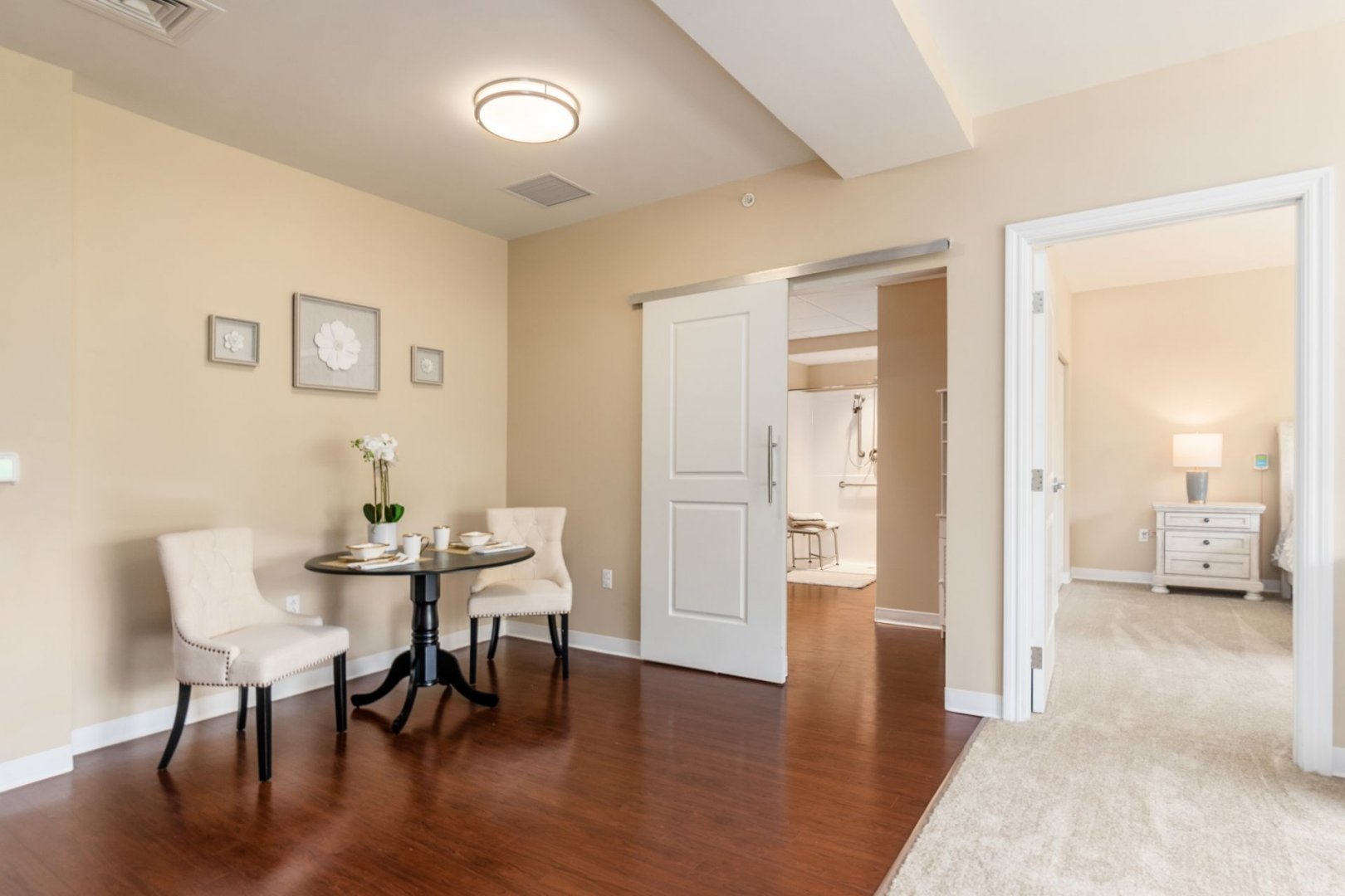 Cozy dining area in senior unit, with a table set for two, adjacent to bedroom and bathroom.