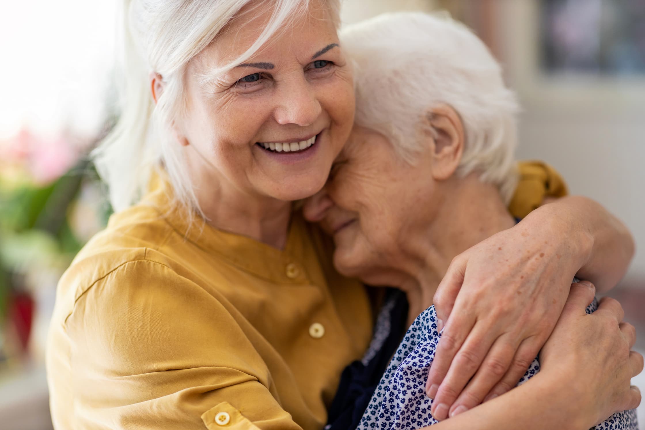 seniors women embracing and smiling
