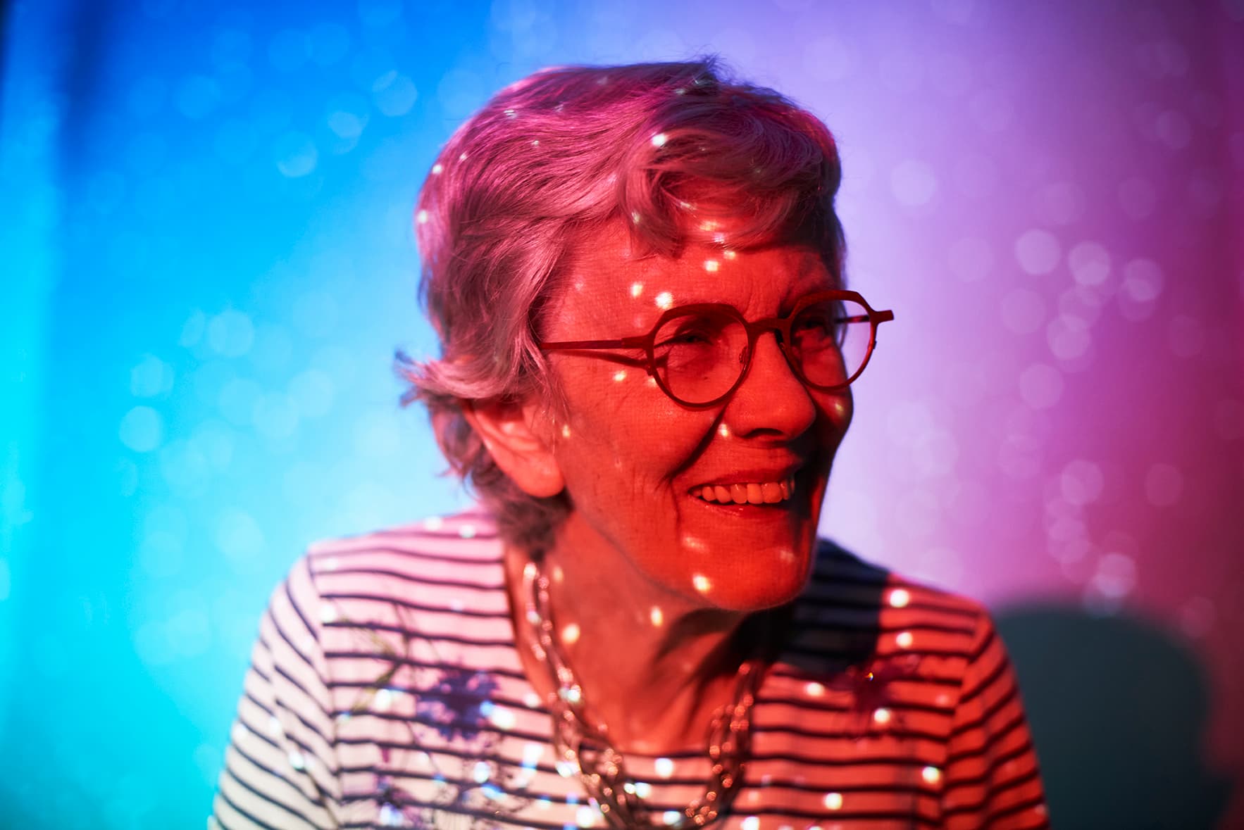 senior woman smiling in tovertafel lights
